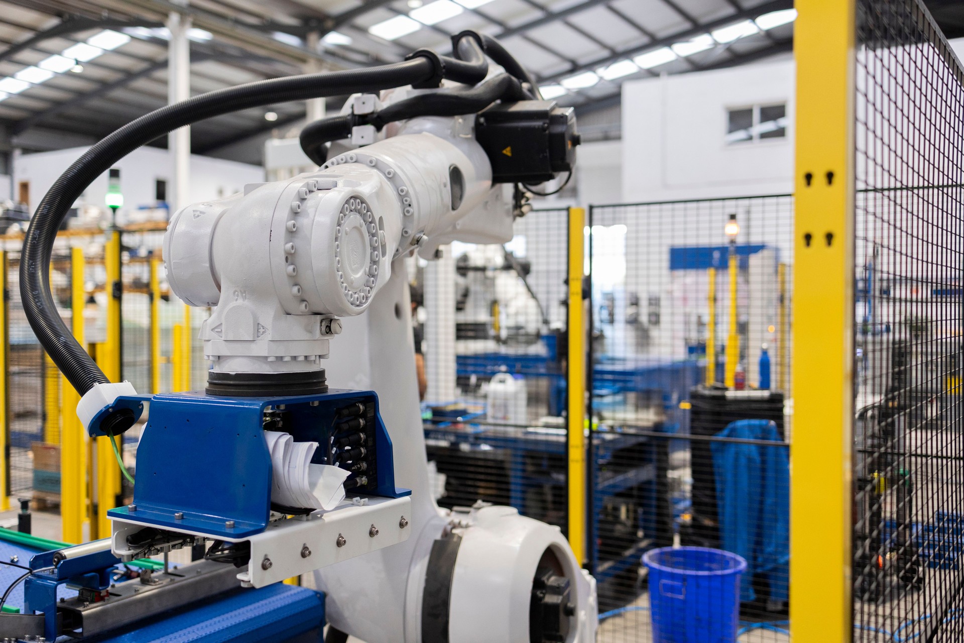 Robotic arm handling material on assembly line in factory