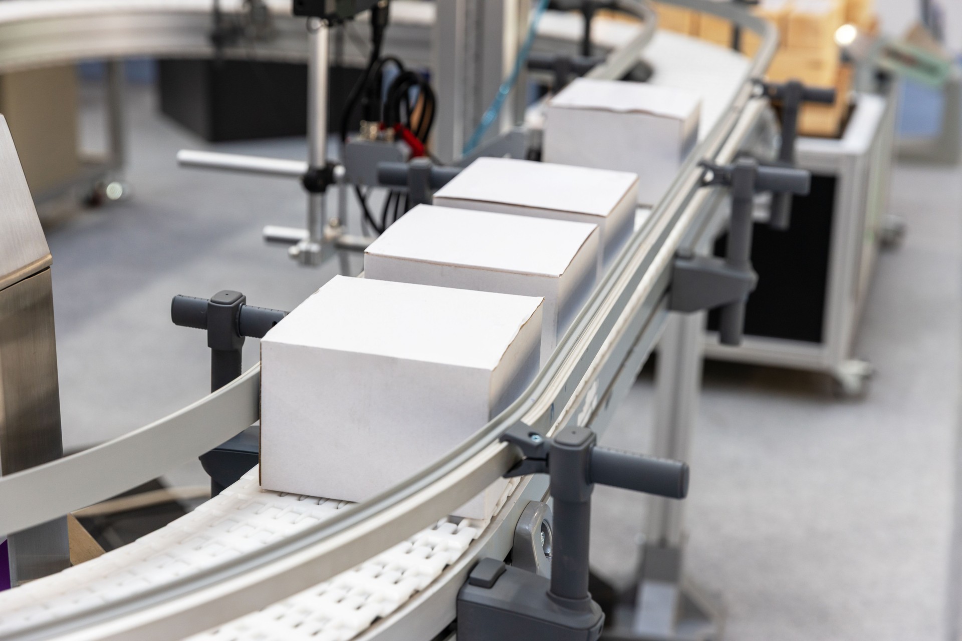 Automated conveyor belt transporting cardboard boxes in a smart packaging and logistics facility